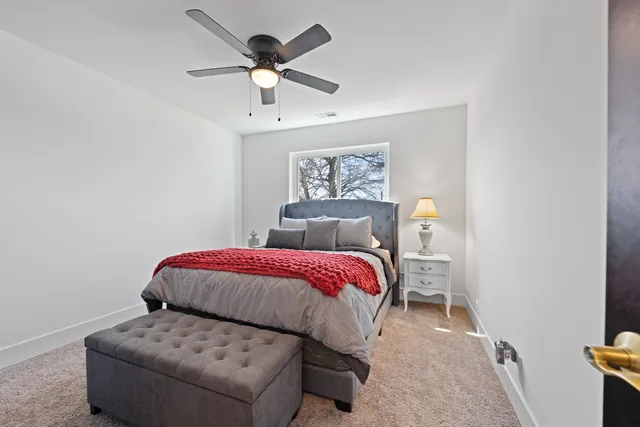 a bedroom with a large bed and a chandelier