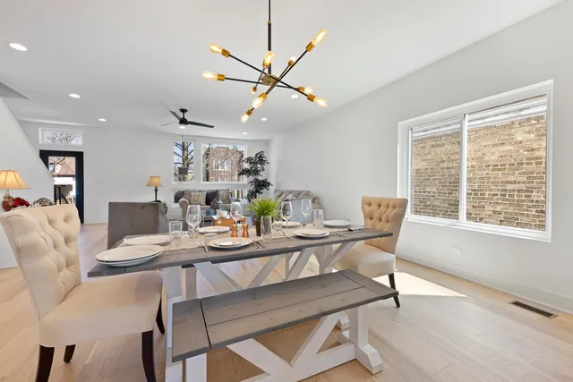 a living room with furniture a chandelier and a dining table