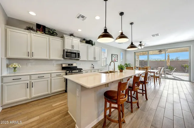 a kitchen with stainless steel appliances granite countertop a stove a sink a microwave a center island and cabinets