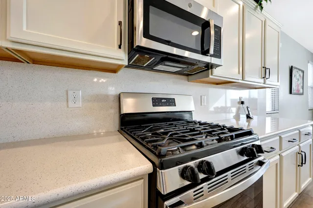 a kitchen with stainless steel appliances granite countertop a stove and a microwave