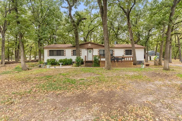 a front view of a house with a yard and trees