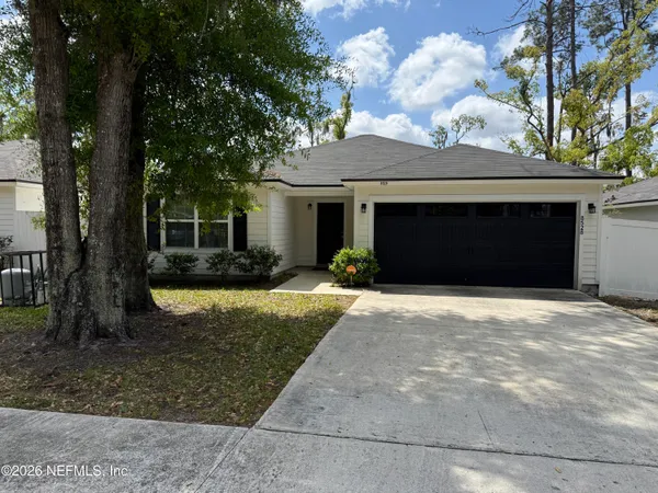 a front view of a house with a yard and garage