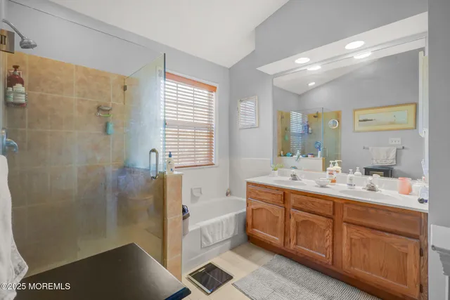 a spacious bathroom with a double vanity sink a mirror and a bathtub