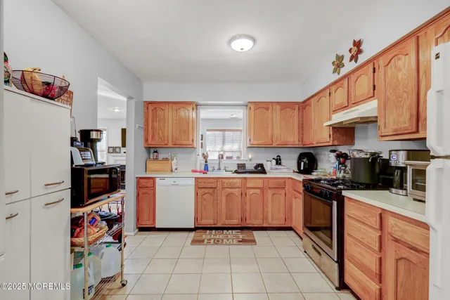 a kitchen with stainless steel appliances granite countertop a refrigerator sink and stove