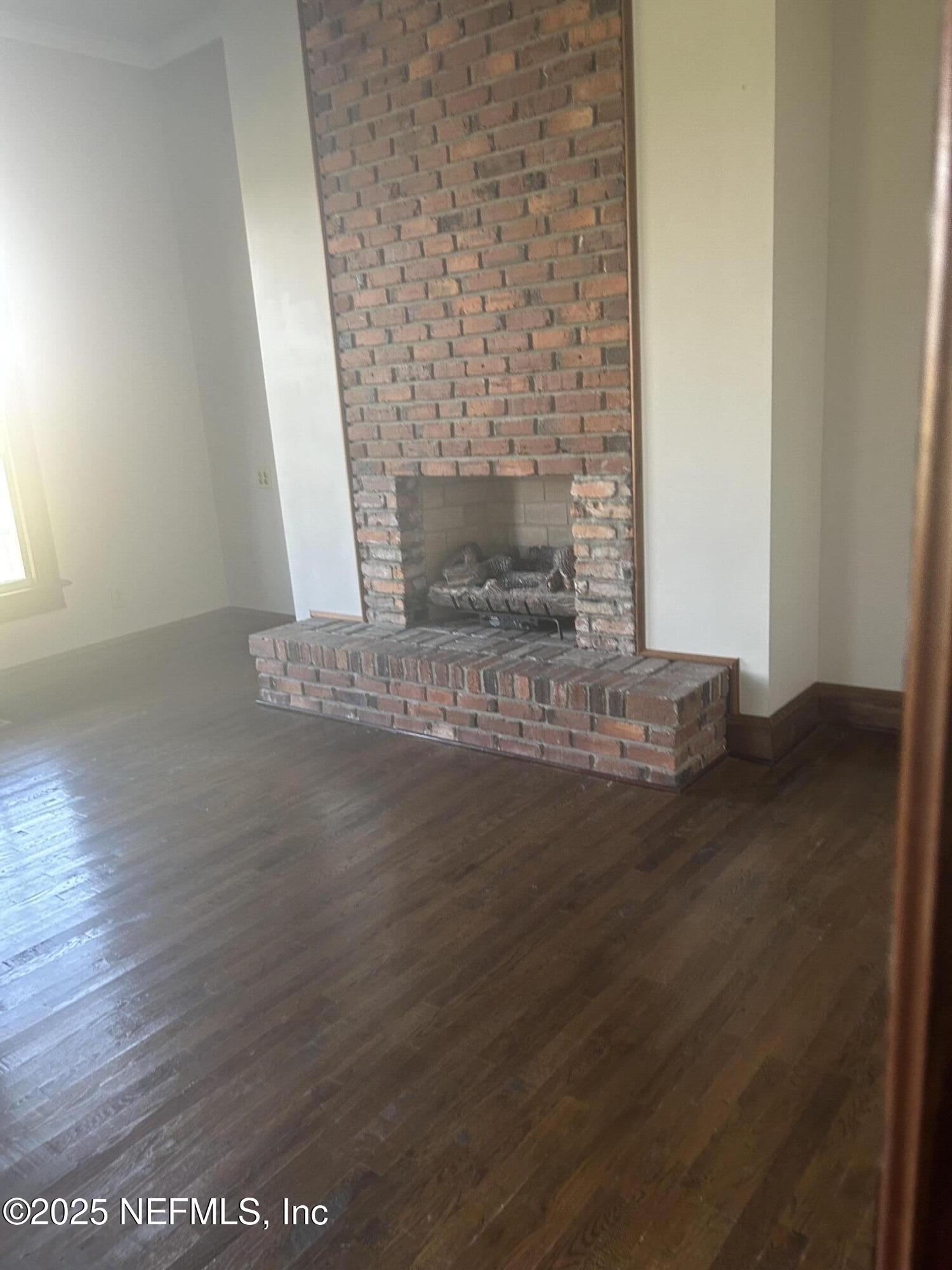 9897 Adams Road Wellborn, FL 32094 - Photo 5 of 12 a view of empty room with wooden floor and fireplace
