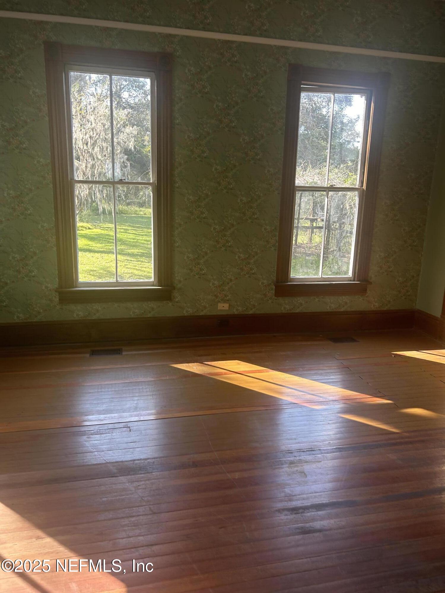 9897 Adams Road Wellborn, FL 32094 - Photo 6 of 12 an empty room with wooden floor and windows