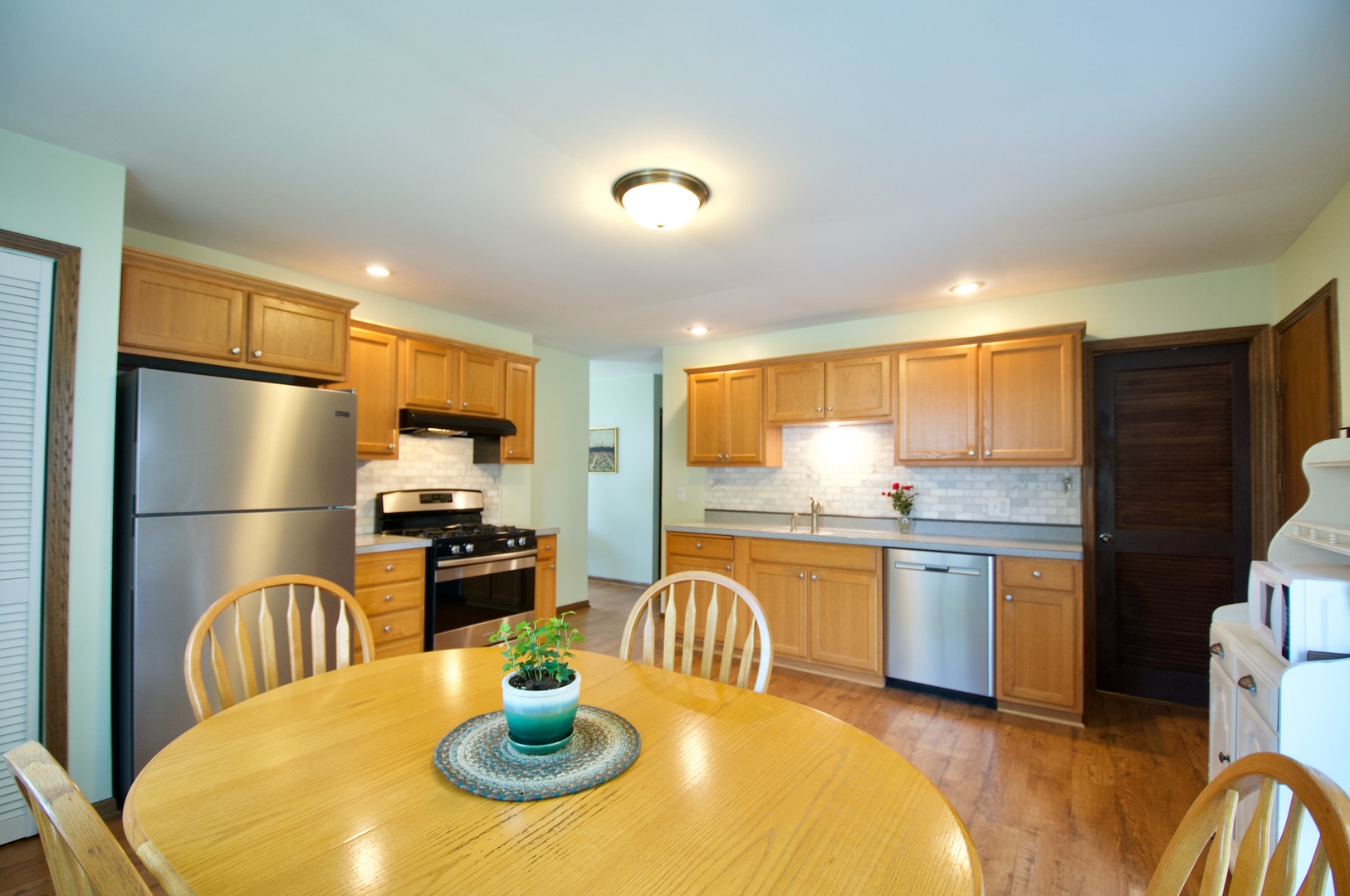 150 Heathgate Road Montgomery, IL 60538 - Photo 5 of 25 a kitchen with stainless steel appliances granite countertop a kitchen island a stove a refrigerator a dining table and chairs