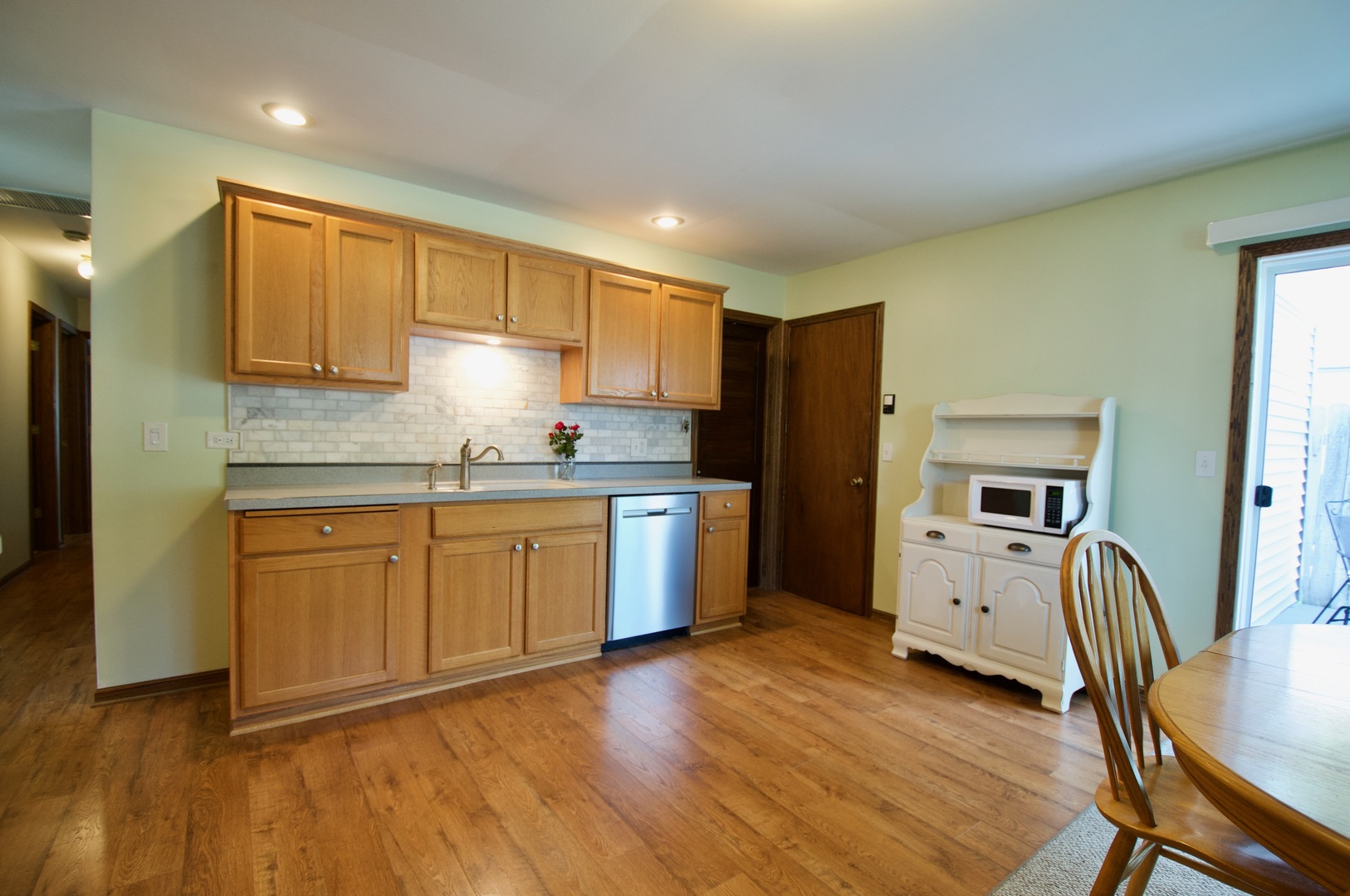150 Heathgate Road Montgomery, IL 60538 - Photo 6 of 25 a kitchen with granite countertop wooden floors white cabinets and stainless steel appliances