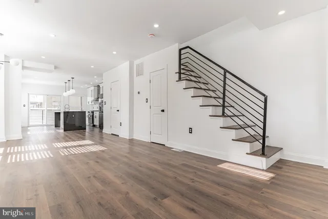 a view of a big room with wooden floor and windows