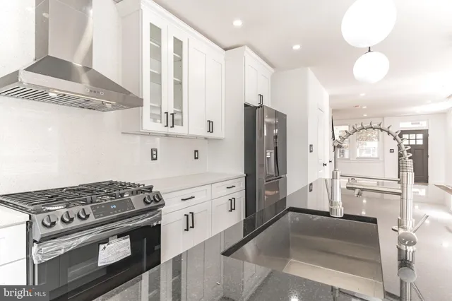 a kitchen with stainless steel appliances granite countertop a stove and a refrigerator