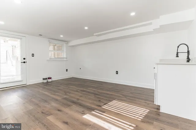 a view of a room with wooden floor and white walls