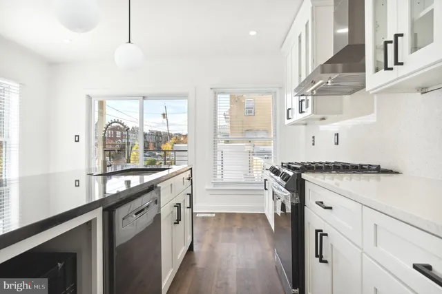 a kitchen with stainless steel appliances granite countertop a stove and a white cabinets