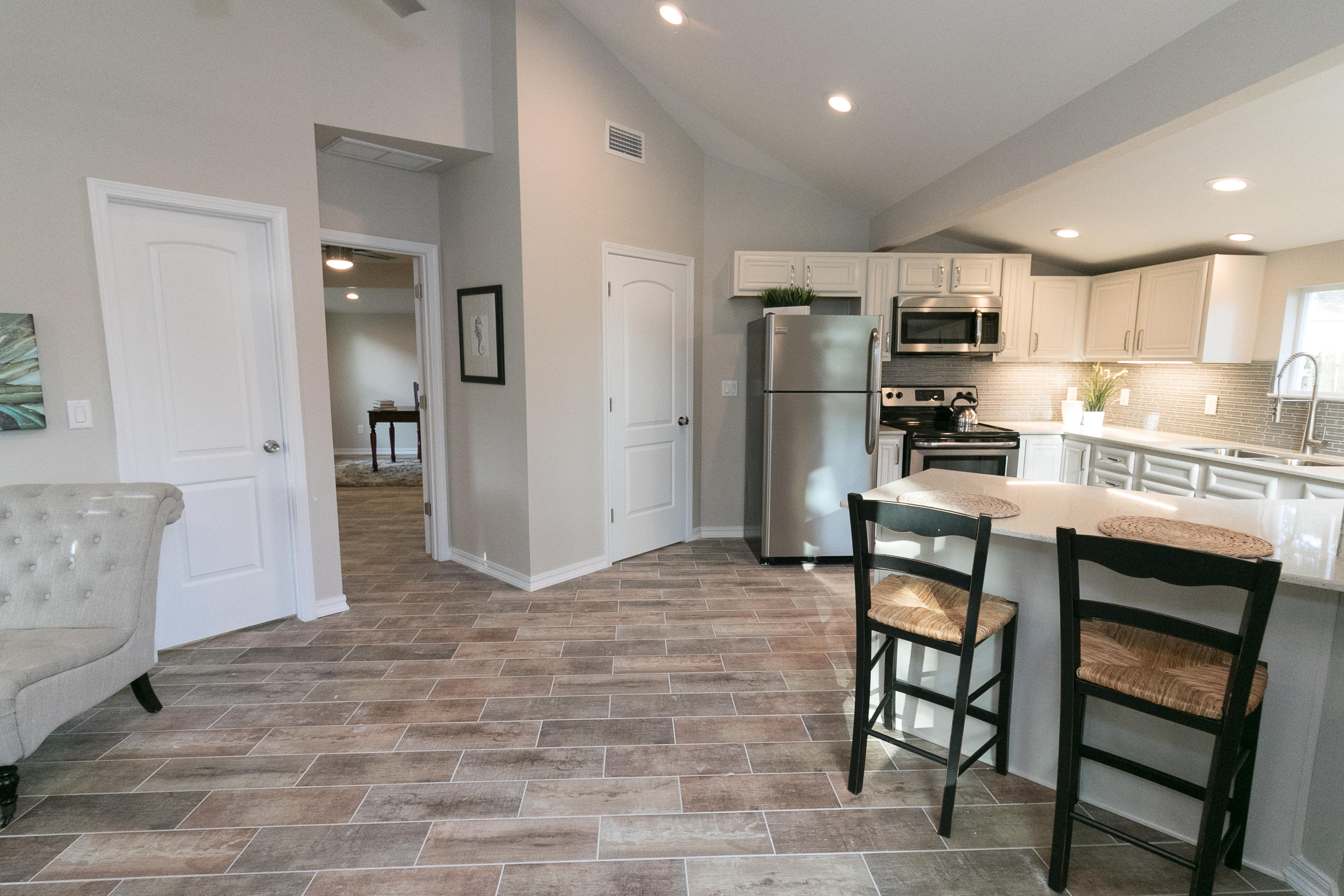 502 3rd Avenue Destin, FL 32541 - Photo 3 of 18 a kitchen with stainless steel appliances kitchen island granite countertop a refrigerator and a stove top oven