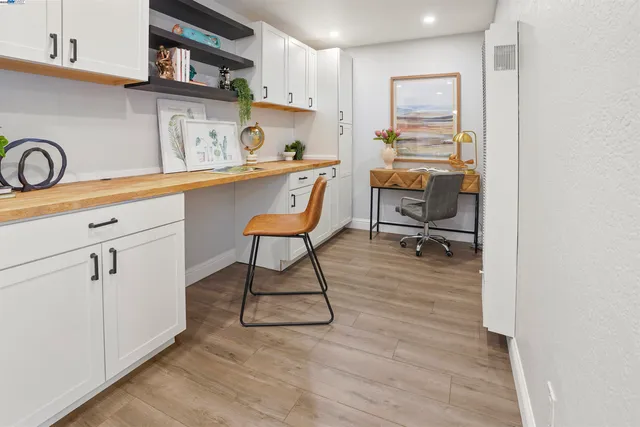 a room with stainless steel appliances kitchen island hardwood floor and a sink