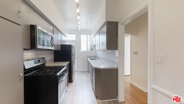 a kitchen with stainless steel appliances granite countertop a refrigerator a sink and a stove