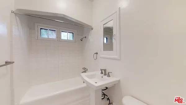 a bathroom with a sink mirror bathtub and toilet