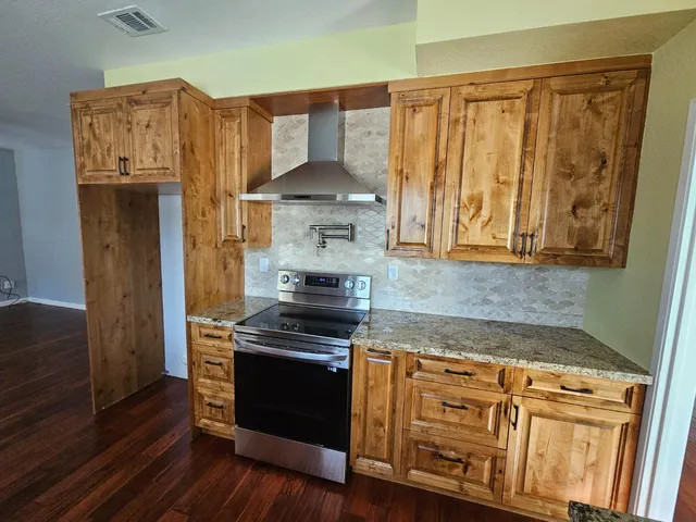 a kitchen with granite countertop wooden cabinets and white appliances