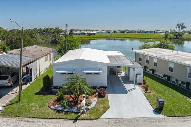 an aerial view of a house with a garden and lake view