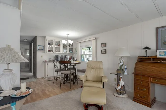 a living room with furniture and a dining table with lamp