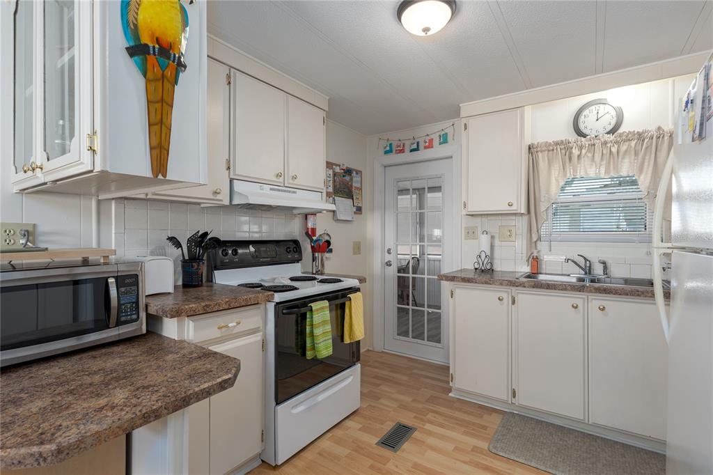 1416 41st Avenue East Ellenton, FL 34222 - Photo 9 of 26 a kitchen with stainless steel appliances granite countertop a stove a sink and a microwave