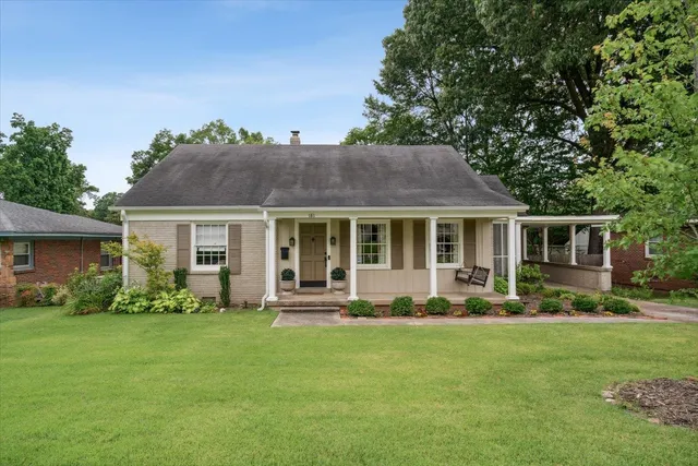 a front view of a house with a garden and yard