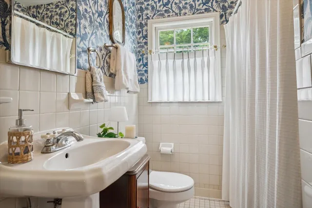 a bathroom with a sink a toilet and a mirror
