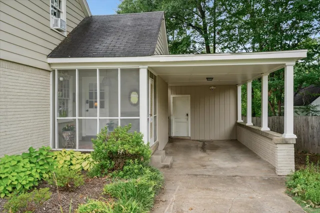 a view of a house with a large window and plants