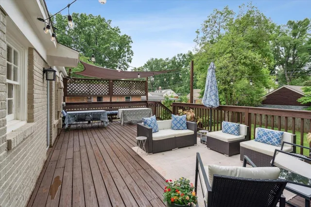 a view of deck with table and chairs potted plants with wooden floor and fence