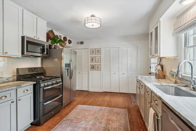 a kitchen with stainless steel appliances granite countertop a sink stove and refrigerator