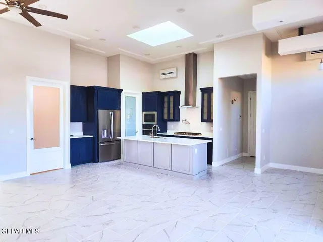 a large kitchen with a lot of counter space and stainless steel appliances