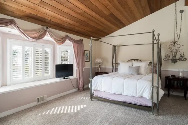 a bedroom with a bed next to a large window with the outer view