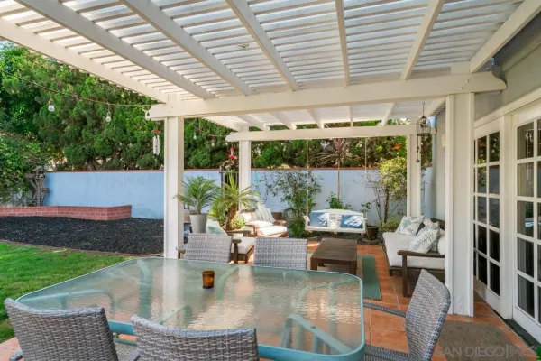 a living room with patio furniture and a garden