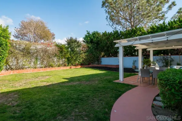 a view of a patio with table and chairs potted plants and large tree