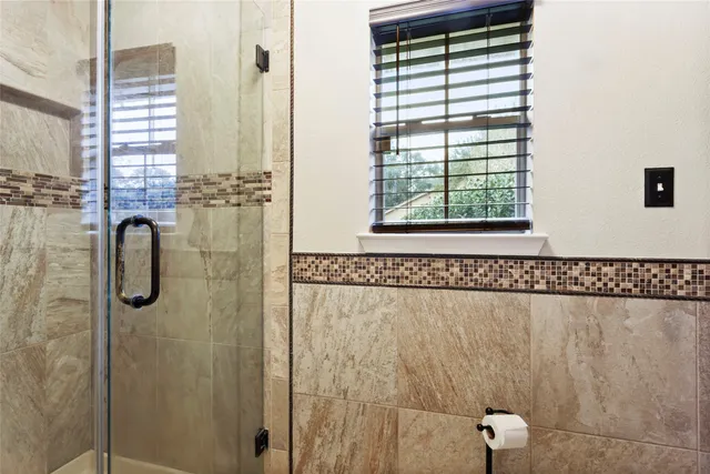 a bathroom with a shower and a window