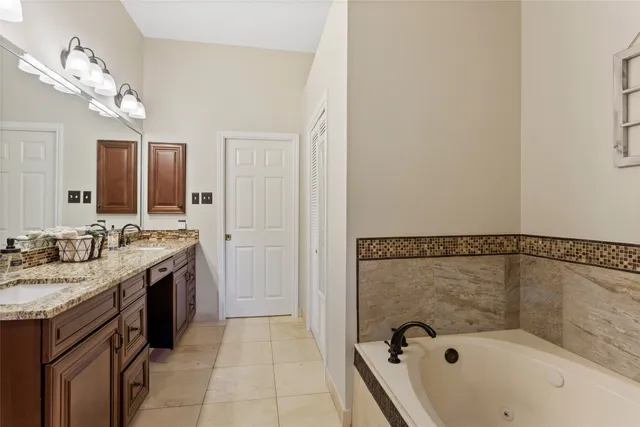 a bathroom with a granite countertop sink a mirror and shower