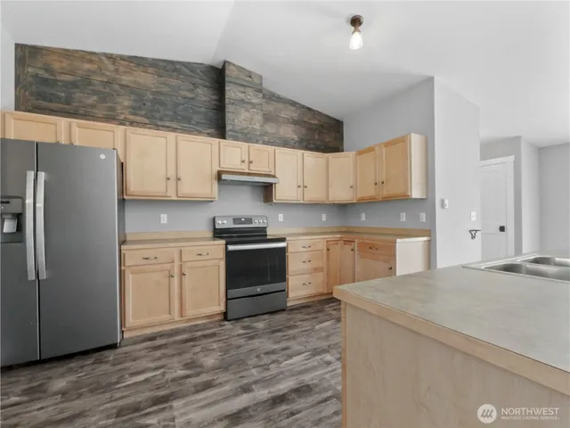 a kitchen with stainless steel appliances a refrigerator sink and cabinets