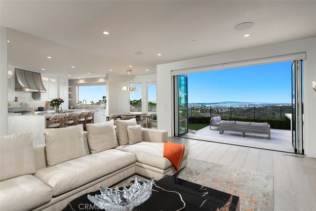 a living room with furniture floor to ceiling window and a table