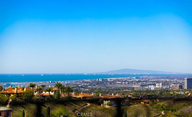 an aerial view of ocean and residential houses with outdoor space