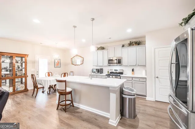 a large kitchen with a table chairs refrigerator and cabinets