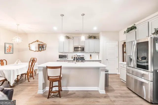 a kitchen with stainless steel appliances kitchen island granite countertop a sink and a refrigerator