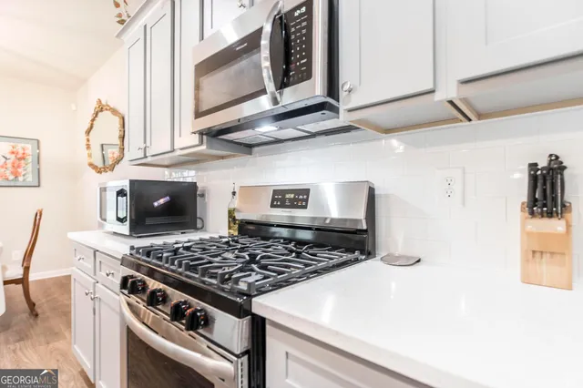 a kitchen with stainless steel appliances granite countertop a stove and a microwave