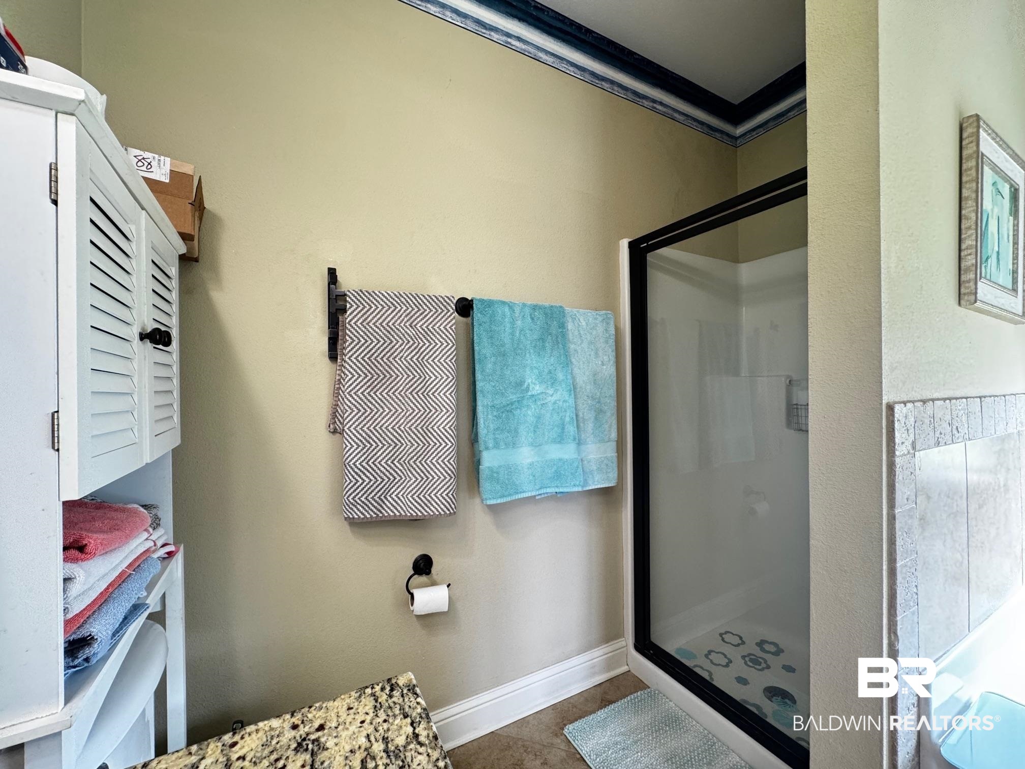 1030 Crown Walk Drive Foley, AL 36535 - Photo 18 of 40 Full bathroom featuring baseboards, crown molding, a shower stall, and tile patterned flooring