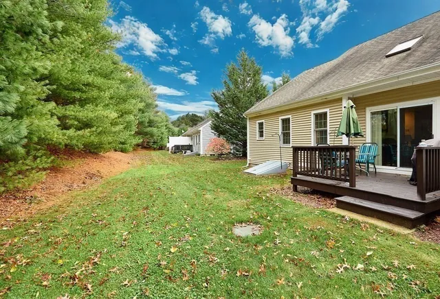 a view of a white house with a yard and sitting area