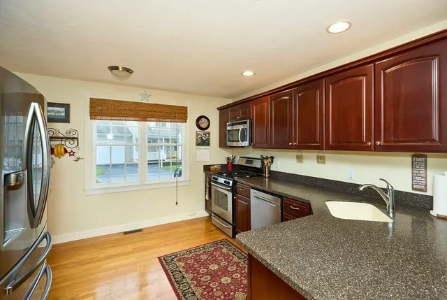 a kitchen with stainless steel appliances granite countertop a refrigerator and a sink