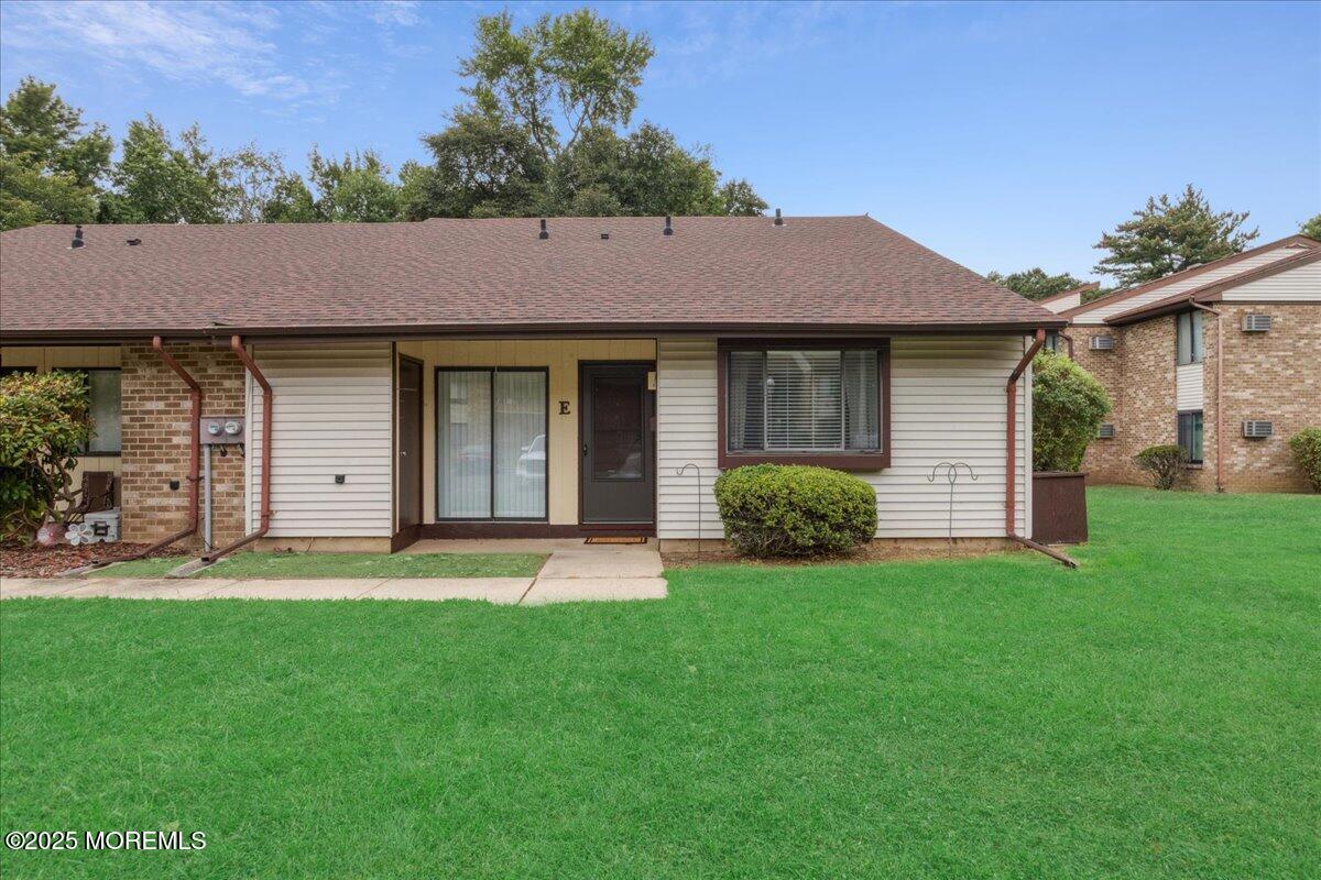 70 Overlook Way, Unit E Manalapan, NJ 07726 - Photo 2 of 21 a backyard of a house with table and chairs