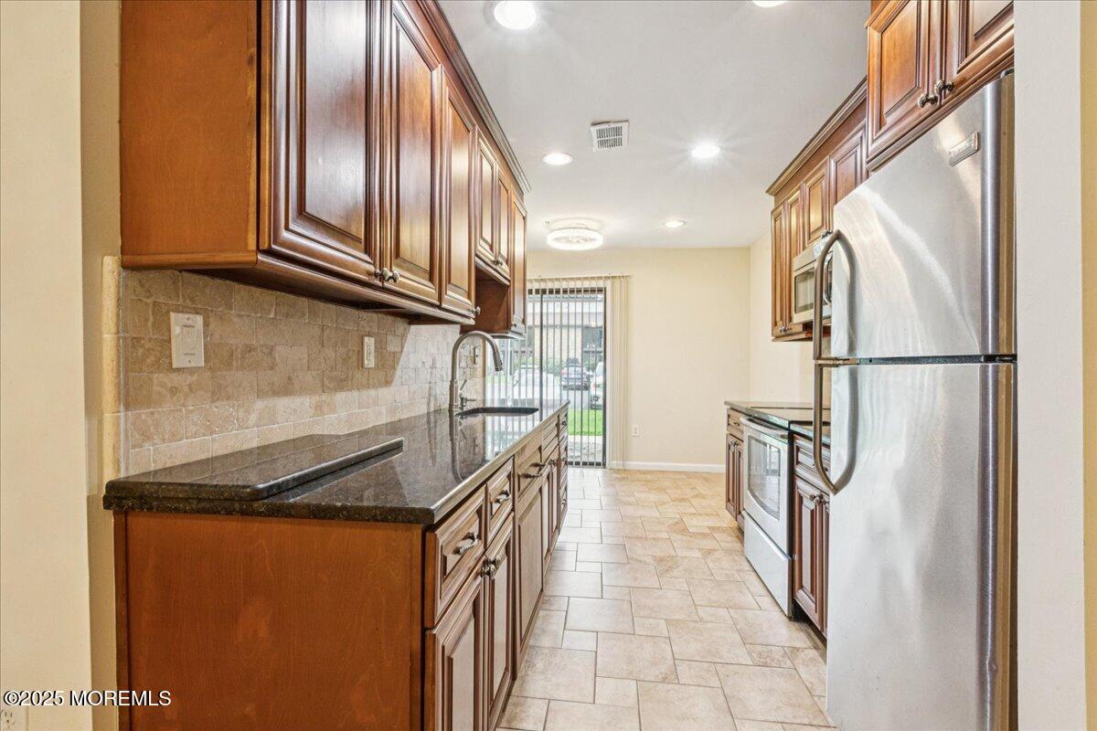 70 Overlook Way, Unit E Manalapan, NJ 07726 - Photo 4 of 21 a kitchen with stainless steel appliances granite countertop a refrigerator and a sink