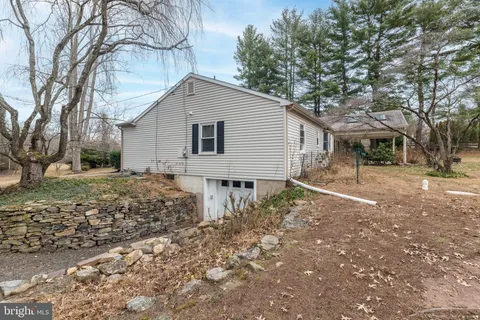 a backyard of a house with large trees and barbeque oven