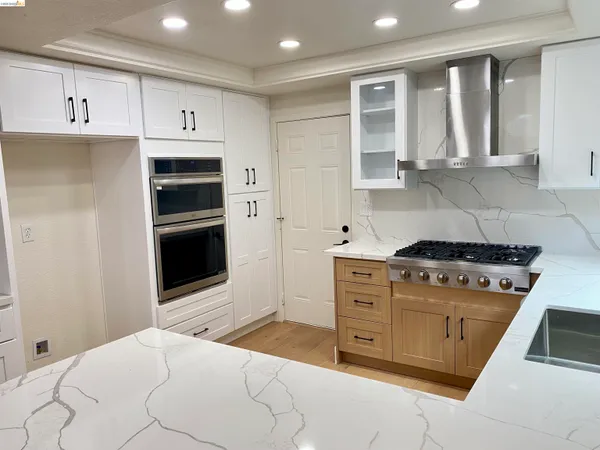 a kitchen with stainless steel appliances granite countertop a stove and a refrigerator