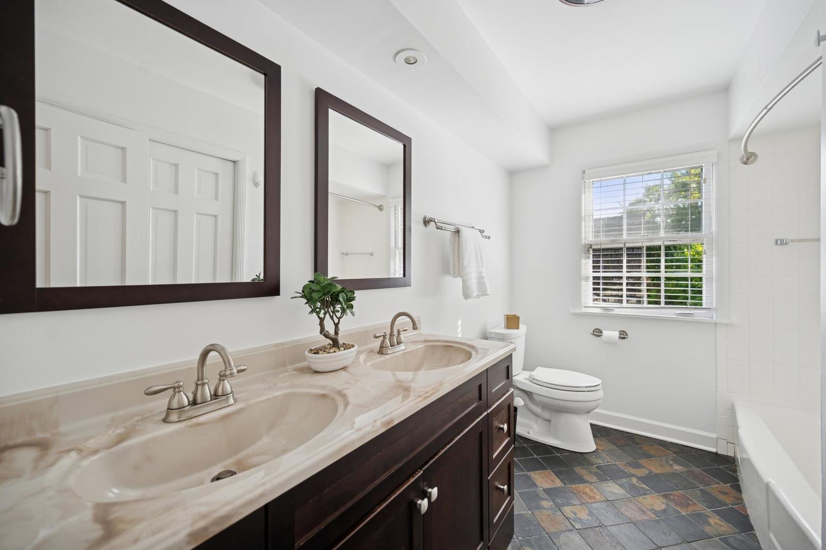 32 Meadowview Road Northfield, IL 60093 - Photo 48 of 69 a bathroom with a granite countertop toilet a sink a mirror and a window