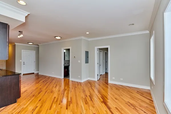 a view of empty room with wooden floor
